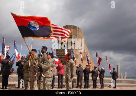 Soldiers of the 29th Infantry Division Color Guard, participate in a ceremony honoring World War II veterans held at the Omaha Beach memorial in St. Laurent-Sur-Mer,, France, June 6, 2017. The ceremony commemorates the 73rd anniversary of D-Day, the largest multi-national amphibious landing and operational military airdrop in history, and highlights the U.S.' steadfast commitment to European allies and partners. Overall, approximately 400 U.S. service members from units in Europe and the U.S. are participating in ceremonial D-Day events from May 31 to June 7, 2017. Stock Photo