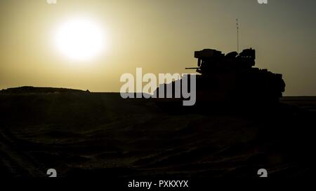 A Bradley fighting vehicle provides over watch for an M1A2 Abrams tank during the Company D, 6th Squadron, 9th U.S Cavalry Regiment, 3rd Armored Brigade Combat Team, 1st Cavalry Division, “Hunter Killer” table 12 qualification, June 7, Udairi Range, Kuwait. “Hunter Killer” involves multiple armored vehicles in formation to conduct offensive and defensive firing maneuvers. Stock Photo