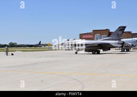 An F-16 Falcon from the 114th Fighter Wing, Sioux Falls, SD sits on the ramp at the Air National Guard base in Sioux City, Iowa as a B-52 Stratofortress from the 5th Bomb Wing, Minot Air Force Base, ND, taxis towards the ramp in preparation for an Open House to be held at the 185th Air Refueling Wing on Saturday June 10, 2017. Stock Photo