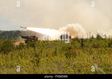 ADAZI MILITARY BASE, Latvia – M142 High Mobility Artillery Rocket System, fired by U.S. Army National Guard 3rd Battalion, 157th Field Artillery Regiment, 169th Fires Brigade, Colorado Army National Guard, shoots through the sky in a demonstration at Adazi Military Base, Latvia, June 9.  The demonstration is part of a mass offensive attack, featuring the capabilities of U.S. Air Force, U.S. Army, and U.S. Marine assets, as well as Polish tanks and Italian Mechanized Infantry.  The exercise falls under Saber Strike, a U.S. Army Europe-led multinational combined forces training exercise in the B Stock Photo