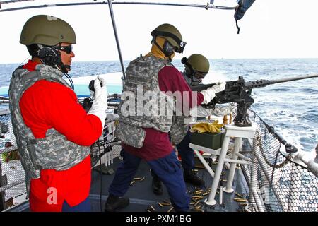 U.S. Coast Guard Assistant Operations Officer 1st Class Miguel Sanchez-Taylor (left), a Miami, Florida native serving on the USCG Cutter Winslow Griesser, receives commands to fire the .50 caliber machine gun during Exercise Tradewinds 2017 at the Barbados Coast Guard, June 8, 2017. Military and civilians from 20 countries are participating in this year’s exercise in Barbados, and Trinidad and Tobago, which runs from June 6-17, 2017. Stock Photo