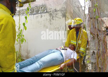 Fire officers from the Bridgetown Fire Department assess and assist a volunteer actor during a mass casualty drill at the site of the former Glendairy Prison. The scenario was based on the idea that an earthquake caused a hotel to collapse and local emergency services and Barbados Defence Force (BDF) personnel were working together to rescue and treat survivors. Tradewinds 2017 Regional Observer and Assessment Team (ROAT) members from multiple countries watched the exercise to take notes and create an assessment for Barbadian officials. The report will contain ideas of ways emergency services  Stock Photo