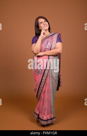 Full body shot of Indian woman wearing Sari Indian traditional clothes and thinking Stock Photo