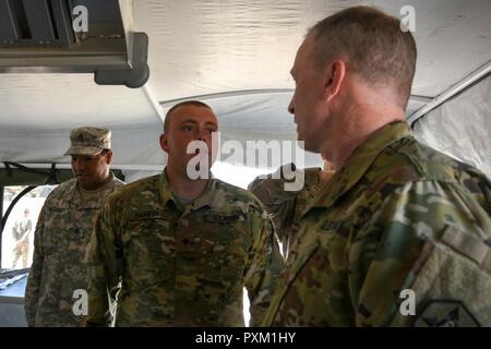 Spc. Blake Hamer, the acting non-commissioned officer in charge of culinary management with the 96th Sustainment Brigade, discusses his section procedures with Brig. Gen. Gregory Mosser, the commanding general of the 364th Expeditionary Sustainment Command, during the exercise Operation Sustain Fury in Ogden, Utah, June 10, 2017. The exercise provides notional scenarios and training parallel to real-world events. Stock Photo