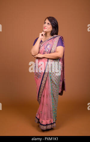 Full body shot of Indian woman wearing Sari Indian traditional clothes and thinking Stock Photo