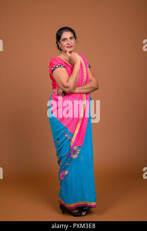 Full body shot of Indian woman wearing Sari Indian traditional clothes and thinking Stock Photo