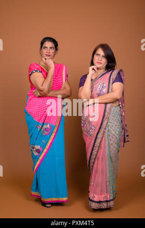 Two mature Indian women wearing traditional clothes and thinking Stock Photo
