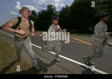 U.S. Air Force Airman 1st Class Travis Roemmele, left, from the New Jersey Air National Guard's 108th Security Forces Squadron finishes the 12km foot march with fellow airmen helping him along during a German Armed Forces Badge for Military Proficiency test at Joint Base McGuire-Dix-Lakehurst, N.J., June 13, 2017. The test included an 1x10-meter sprint, flex arm hang, 1,000 meter run, 100 meter swim in Military Uniform, marksmanship, and a timed foot march. Stock Photo