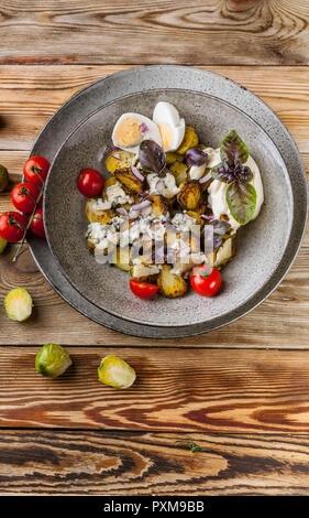 Fried brussels sprouts with Dorblu cheese, egg and red onion. Vertical shot Stock Photo