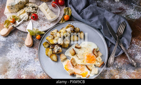 Fried eggs with croutons, sprouts, butter, cheese and a baguette with pumpkin seeds, close-up delicious breakfast concept Stock Photo