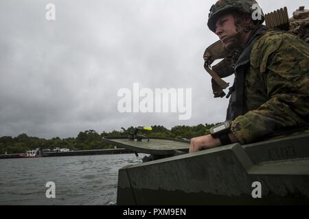 A Marine observes his surroundings while floating in water on a light armored vehicle during a field exercise at Camp Lejeune, N.C., June 8, 2017. The Marines participated in the exercise to test the amphibious capabilities of LAVs while highlighting the importance of swift, accurate reconnaissance for future operations. The Marines are with 2nd Light Armored Reconnaissance Battalion. Stock Photo
