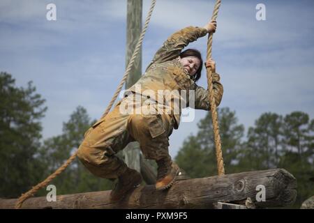 Staff Sgt. Marcy DiOssi, a bridge crewmember-instructor with the 80th Training Command (The Army School System), swings onto a wooden beam as part of the 2017 U.S. Army Reserve Best Warrior Competition, Fort Bragg, N.C., June 13, 2017. Competitors must try to complete as many obstacles as they can, as fast as they can. The obstacle course is only one event in the entire competition. This year’s Best Warrior Competition will determine the top noncommissioned officer and junior enlisted Soldier who will represent the U.S. Army Reserve in the Department of the Army Best Warrior Competition later  Stock Photo