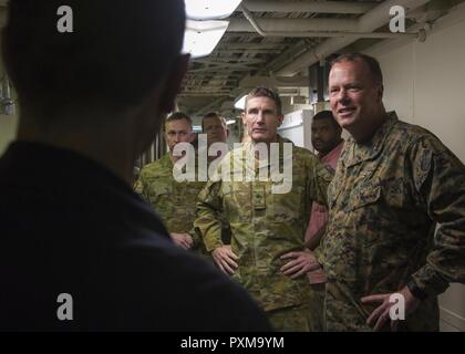 Commanding General of 3d Marine Aircraft Wing, Maj. Gen. Mark R. Wise, right, and Chief of the Australian Army, Lieutenant General Angus Campbell, second from right, speak with crew aboard the amphibious assault ship USS America (LHA 6) off the coast of Southern Calif., June 12, 2017. Maj. Gen. Wise and Lieutenant General Campbell flew with VMM-363 to visit the amphibious assault ship USS America (LHA 6) to receive a tour and view the capabilities of the ship. Stock Photo