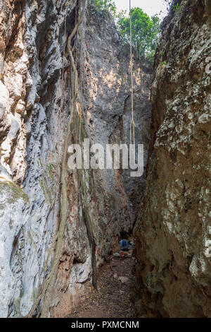 A narrow canyon with two steep, tall and huge limestone faces which is a popular rock climbing site in Vang Vieng, Laos. Stock Photo