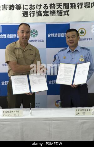 GINOWAN, OKINAWA, Japan— Col. Peter Lee, left, and Ginowan Police Chief  Osamu Hamada shake hands after signing a base access agreement June 13 at  the Ginowan Police Department, Okinawa, Japan. The agreement allows Ginowan  PD's ...