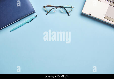 On a blue background notebook, glasses. Concept of education or back to school. Top view, flat lay. Stock Photo