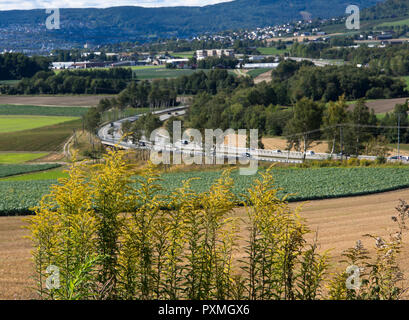 The agricultural landscape and the E-18 motorway in Lier near Drammen Norway, seen from the old railway line converted to a cycle and hiking route Stock Photo