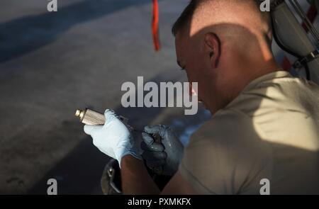 Senior Airman Brandon Murdaugh, a 455th Expeditionary Aircraft Maintenance Squadron crew chief, inspects a constant speed drive filter before installing it on an F-16 Fighting Falcon at Bagram Airfield, Afghanistan, June 16, 2017. CSDs are mainly used on airliner and military aircraft jet engines to drive the alternating current electrical generator. Stock Photo
