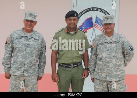 Brig. Gen. David Jones, commander of the Belize Defence Force, Chief Warrant Officer 3 Herminio Romero and Staff Sgt. Juan Cruz with 448th Engineering Battalion, Puerto Rico stand in front of the newly opened Double Head Cabbage Polyclinic adjacent to Rural Belize High School which they were all a part of building 20 years prior in Double Head Cabbage, Belize June 14, 2017. The polyclinic is one of multiple clinics constructed during Beyond the Horizon 2017. BTH is a U.S. Southern Command-sponsored, Army South-led exercise designed to provide humanitarian and engineering services to communitie Stock Photo