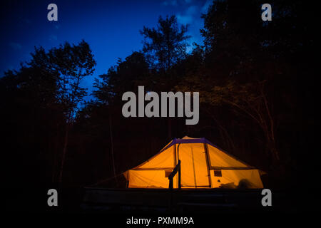 Illuminated family tent at night in Adrenaline Check eco resort in Slovenia. Stock Photo