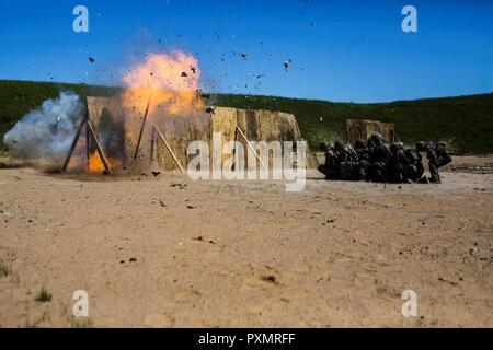 U.S. Marines with Black Sea Rotational Force 17.1 and British Royal Army Commandos detonate an oval charge at a demolition range during Exercise Saber Strike 17 aboard Adazi Military Base, Latvia, June 15, 2017. The exercise is a multinational training evolution designed to increase interoperability between NATO allies and partner nations through combined-arms training. Stock Photo