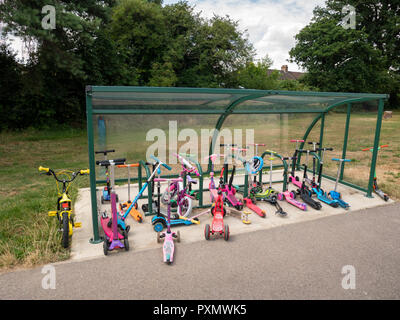 Children's scooters parked up at Worcesters Primary School, Enfield, UK, London Stock Photo