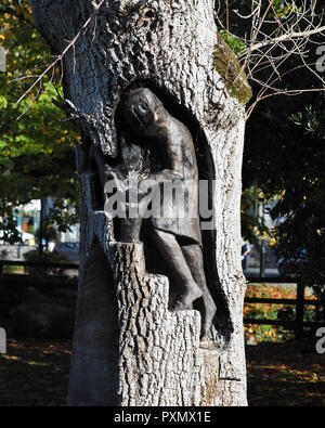 An Goban Saor wood carving in oak tree at Inch field beside Cahir Castle,  County Tipperary, Ireland Stock Photo