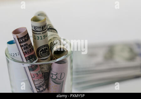 Dollar  and euro banknotes are  in the glass bottle on the table. Stock Photo