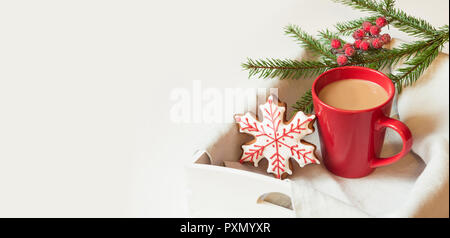 Red cup of hot coffee with christmas gingerbread on white. Holiday banner. Christmas morning. Stock Photo