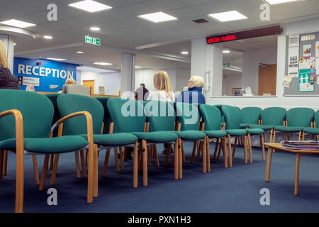 Doctors reception or waiting room with patients UK Stock Photo