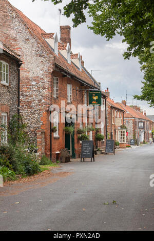 The picturesque village of Castle Acre Norfolk, looking towards Stocks Green, the Ostrich pub and the Albert Victor Inn. England, UK Stock Photo