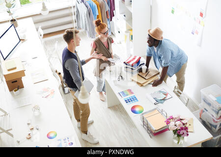 Group of young designers working in team at atelier, they discussing new collection together Stock Photo
