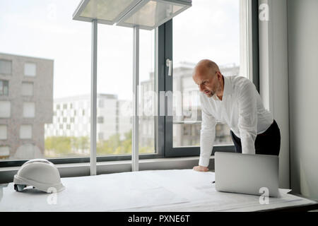 Engineer working in his office, using laptop Stock Photo