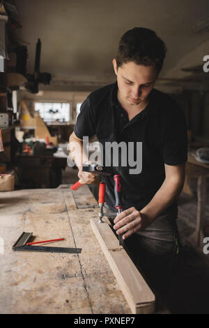 Carpenter working on piece of wood in workshop Stock Photo