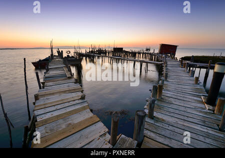 Wooden pillars piers, a palafite fishing harbour of Carrasqueira at dusk. Alentejo, Portugal Stock Photo