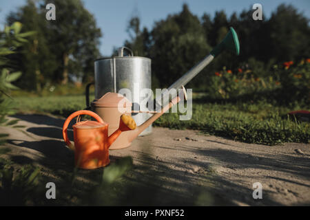 Variation of watering cans in garden Stock Photo