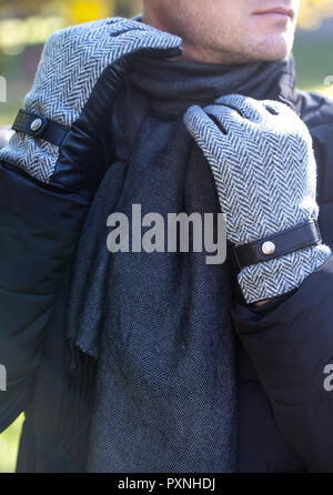 a man in gloves straightens his scarf Stock Photo