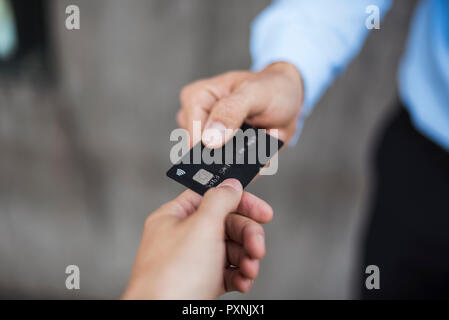 Close-up of businessman handing over credit card Stock Photo