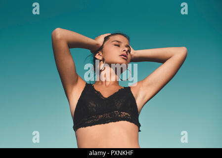 Portrait of teenage girl wearing black top against sky Stock Photo