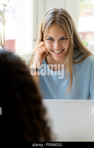 Two friends working at home together, using laptop Stock Photo