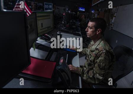 An Airman assigned to the 609th Air Operations Center works on the combat operations division floor at the Combined Air Operations Center at Al Udeid Air Base, Qatar, June 16, 2017. Despite Hurricane Florence hitting South Carolina last week, Airmen assigned to the 609th AOC Detachment 1 at Shaw Air Force Base, South Carolina, continued operations without interruption in support of U.S. Central Command military operations. AFCENT has adopted a distributed command and control model for operations, meaning organizations at multiple locations enable combat operations. Stock Photo