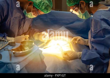 smart medical technology in hospital concept, doctor in Surgeons team field holding medical instruments for surgery the patient in operation room Stock Photo