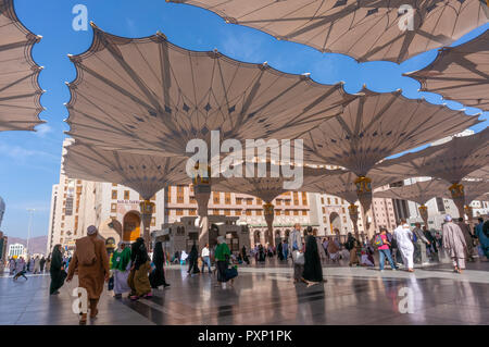 MEDINA,SAUDI ARABIA- CIRCA 2014 : view of giant canopies and pilgrims at Masjid Nabawi (Mosque) compound in Medina, Kingdom of Saudi Arabia. Nabawi mo Stock Photo