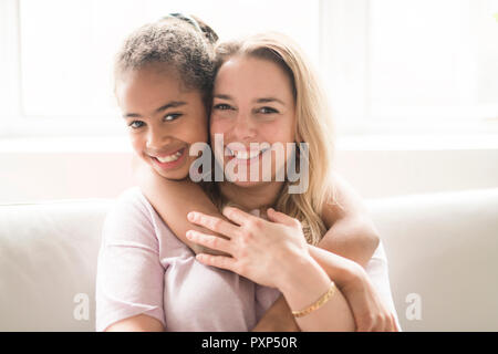 Mother with black child girl on sofa Stock Photo