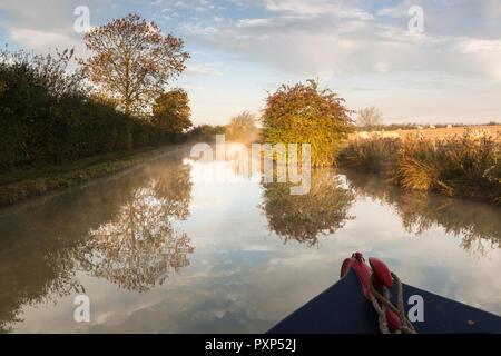 Isolated narrow boat moves along the Oxford Canal early on a sunny autumn morning. Boat is south of Napton. UK Stock Photo