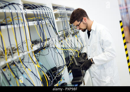 Picture of network technician testing modems in factory Stock Photo