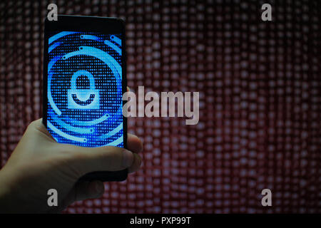 system integrity working while other pass down. hand holding mobile phone with padlock icon on blue binary code screen. Error message in computer. Stock Photo