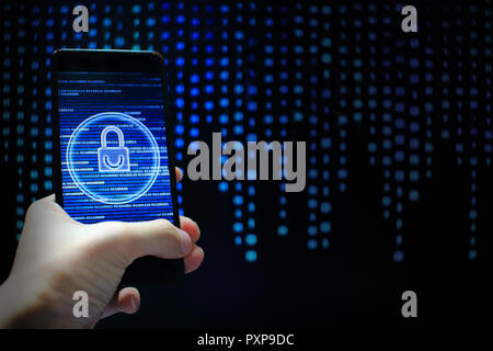 hand hold mobile phone flow. padlock icon symbolize security and motion movement of blue binary code computer data moving in the background. Stock Photo