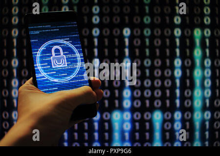hand hold mobile phone flow. padlock icon symbolize security and motion movement of blue binary code computer data moving in the background. Stock Photo