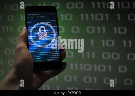 protected in stream of data flow. padlock icon symbolize security and Green binary code computer data in the background. hand holding mobile phone. Stock Photo